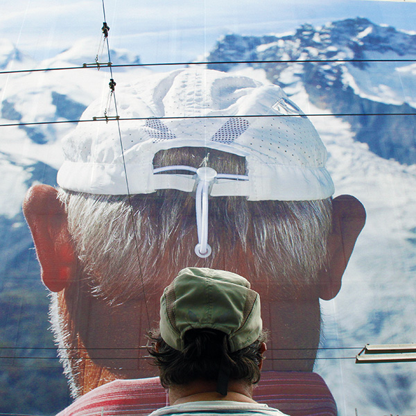 Un portrait géant de Martin Parr réalisé à Zermatt (et ici mis en abyme avec Philippe, modèle d'un jour) occupe la façade entière de la banque cantonale vaudoise. Photo : Pascal Kober.